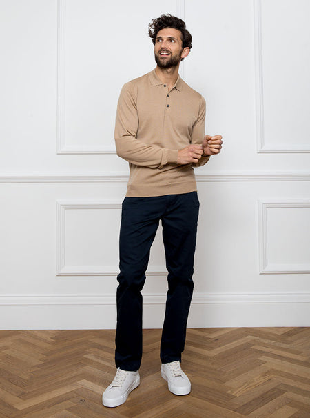 Man wearing light camel long sleeved polo neck sweater knit in 100% luxury and premium merino wool.